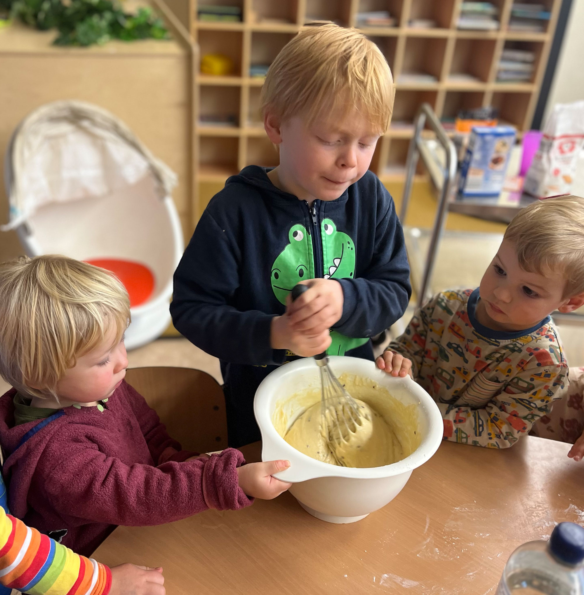 Kinder-jugendcampus-kitakids kita kindern backen gemeinsam, einer rührt in der Schale den Teig um.